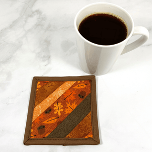 Mug rugs are also known as drink coasters.  They are made from 100% cotton fabric, are insulated and washable too.  These are great accessories for your home office desk or for your coffee bar area.  This particular one is made with strips of fabric, including a gorgeous brown and orange leaf fabric.