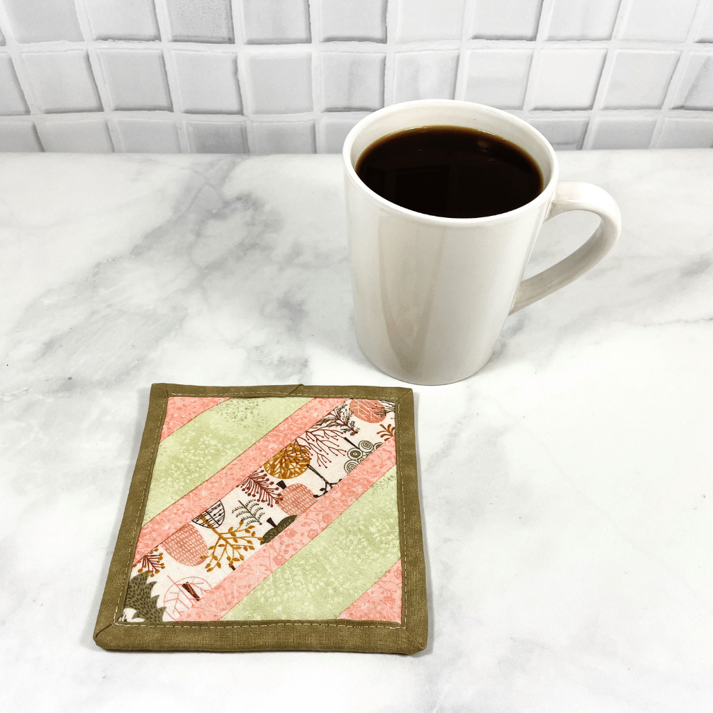 This fun tree themed mug rug is made with strips of fabrics in shades of light pink and mint green.  These mug rugs make great gifts for your coworker or your friend who has everything.   They are insulated, washable and made from 100% cotton.