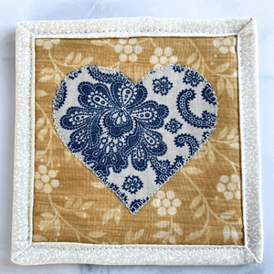 This blue mug rug is made using a heart applique and gives off a wonderful cottagecore vibe.  Any coffee lover or wine lover will love a new drink coaster to set on their end table to help protect the surface.  They are made from 100% cotton, triple stitched at the edge and handmade in Vermont.