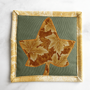 Check out this gorgeous green and gold leaf themed drink coaster.  The mug rug is insulated and washable too.  It makes a great gift for the coffee lover in your life.  And also makes a great desk accessory for your home office decor.
