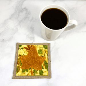 This is a single mug rug aka drink coaster that has a maple leaf applique design on the front.  It measures 5 by 5 inches, is insulated, and washable.  It make a great gift for a coffee lover.  And adds a special flair to any home coffee bar or office desk.