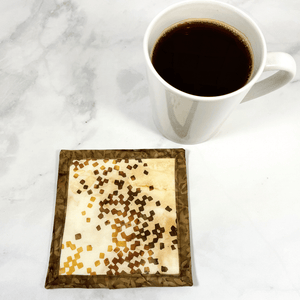 Mug rugs are also known as drink coasters. They are made from 100% cotton fabric, are insulated and washable too. These are great accessories for your home office desk or for your coffee bar area. This particular one is made with a stunning brown and beige batik fabric.