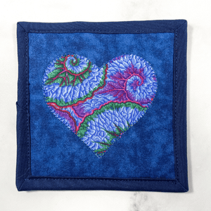 Mug rugs are also known as drink coasters. They are made from 100% cotton fabric, are insulated and washable too. These are great accessories for your home office desk or for your coffee bar area. This particular one is made with a Kaffe Fassett blue fabric made into a heart applique design in the center.