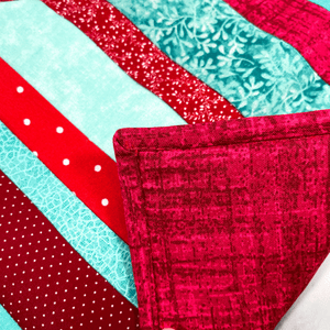 These are a set of two gorgeous red and aqua striped, quilted potholders for your home.  The trivets are made from 100% cotton fabric and are washable.  Practical, yet beautiful when used as hot pads on your kitchen island or dining table.