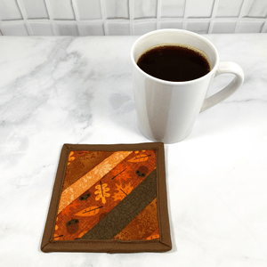 Mug rugs are also known as drink coasters.  They are made from 100% cotton fabric, are insulated and washable too.  These are great accessories for your home office desk or for your coffee bar area.  This particular one is made with strips of fabric, including a gorgeous brown and orange leaf fabric.