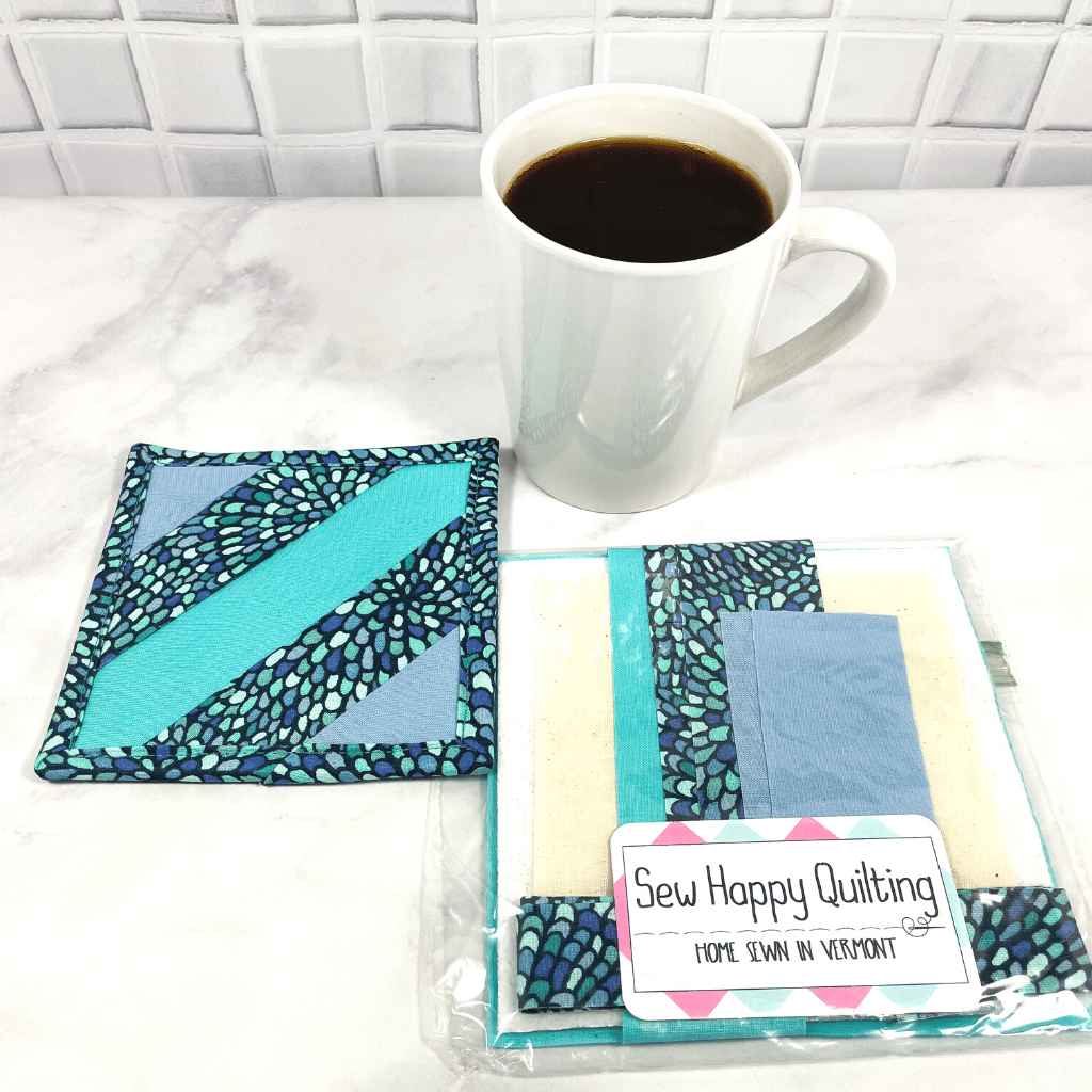 If you love craft kits, check out this quilt kit that will teach you how to make a fabric mug rug aka drink coaster.  Each kit comes with fabric plus printed directions and are mailed to your door.  This one is made with aqua blue mosaic fabric.