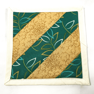 If you love craft kits, check out this quilt kit that will teach you how to make a fabric mug rug aka drink coaster.  Each kit comes with fabric plus printed directions and are mailed to your door.  This one is made with green and gold fabric.