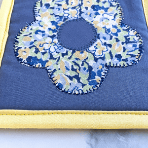 These are yellow and blue flower applique mug rugs. Mug rugs are also known as drink coasters.  They are made from 100% cotton fabric, are insulated and washable too.  These are great accessories for your home office desk or for your coffee bar area, adding a splash of color and uniqueness.